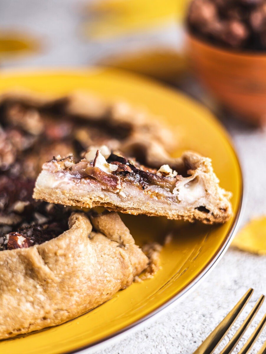 Kawałek galette z figami i serem brie na żółtym talerzu